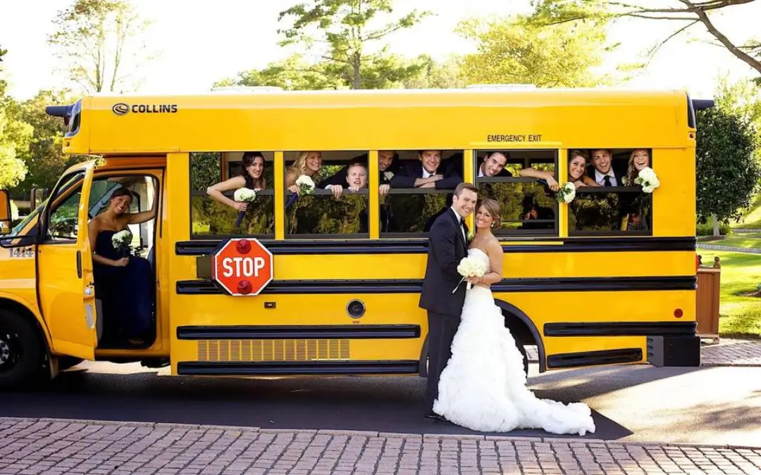 a bride and groom standing in front of a school bus