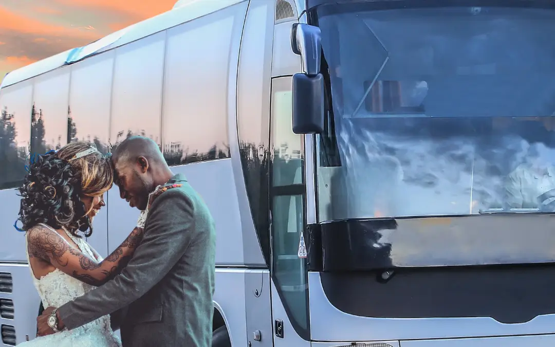 a man and woman standing next to a bus