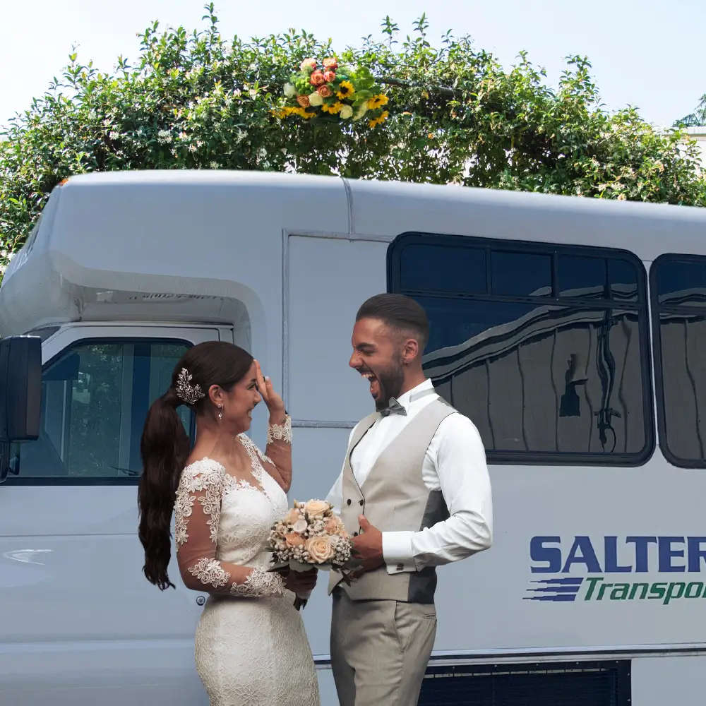 a man and woman in wedding attire standing next to a bus